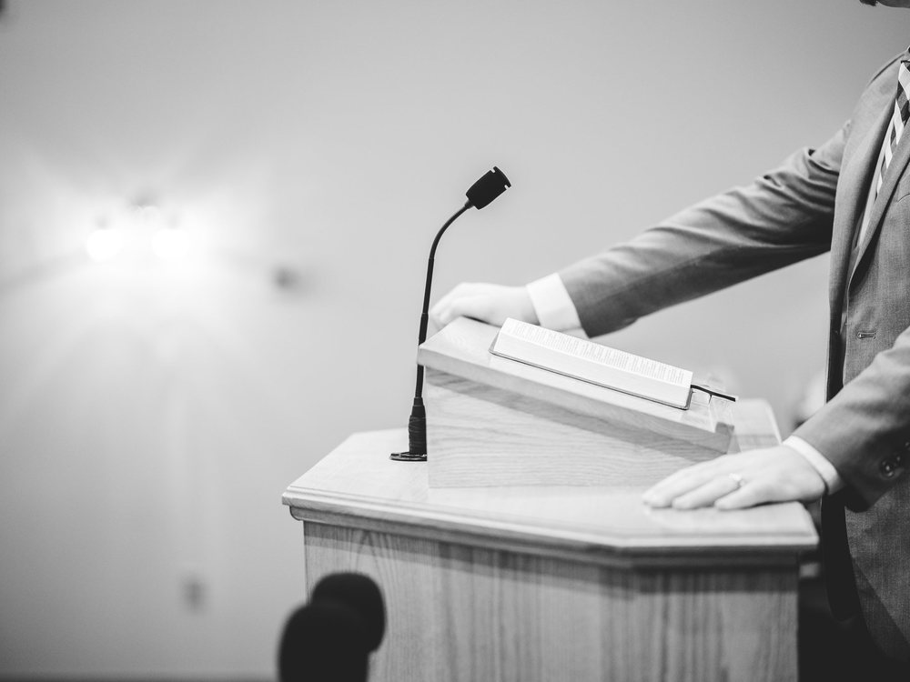 A speaker's hands on a lectern